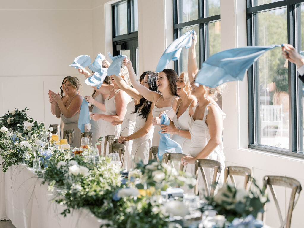 Bridesmaids waving blue napkins at the head table, Bella Giornata reception
