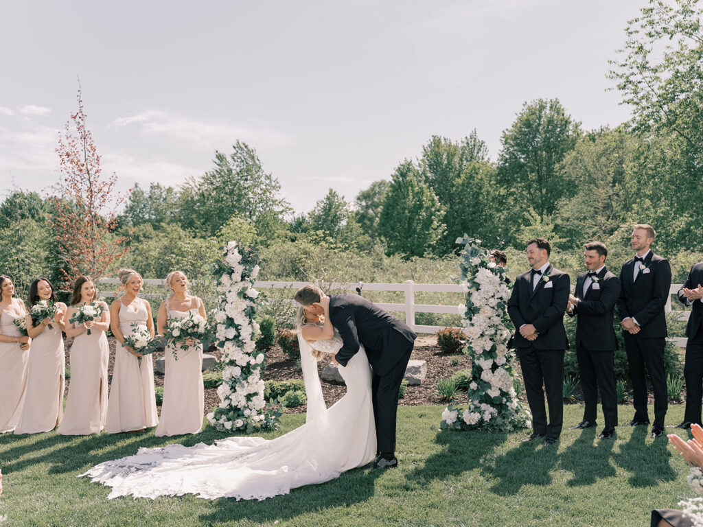 Groom dips bride for their first kiss at Bella Giornata wedding ceremony