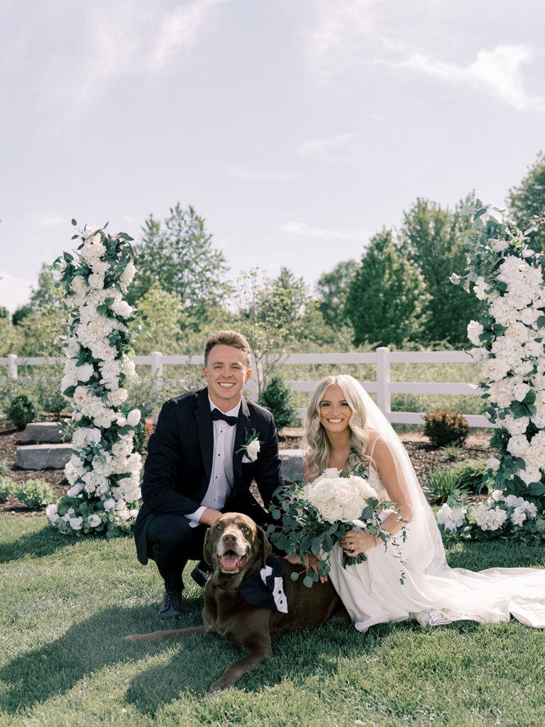 Bride and groom with their dog on the lawn at Bella Giornata wedding